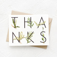 2: Greeting card with capital letters in two stacked rows spelling "THANKS", surrounded by greenery