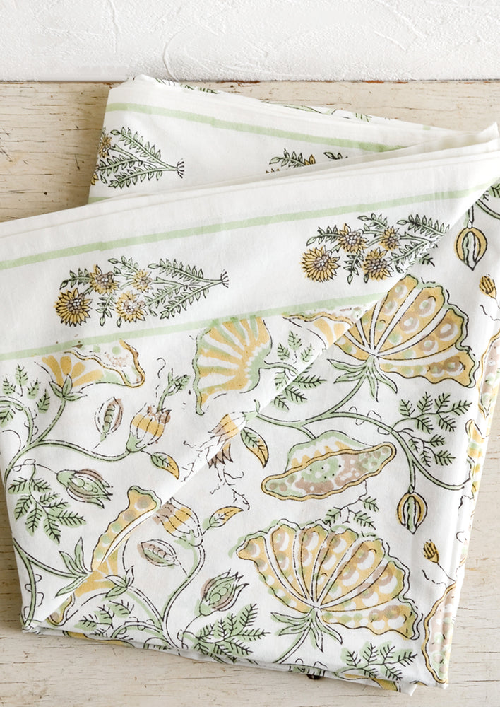 A botanical block printed tablecloth in mint and yellow.