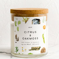 Citrus & Oakmoss: A glass candle with a cork lid and white botanical printed label reading "citrus and oakmoss".