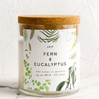 Fern & Eucalyptus: A glass candle with a cork lid and white botanical printed label reading "fern and eucalyptus".