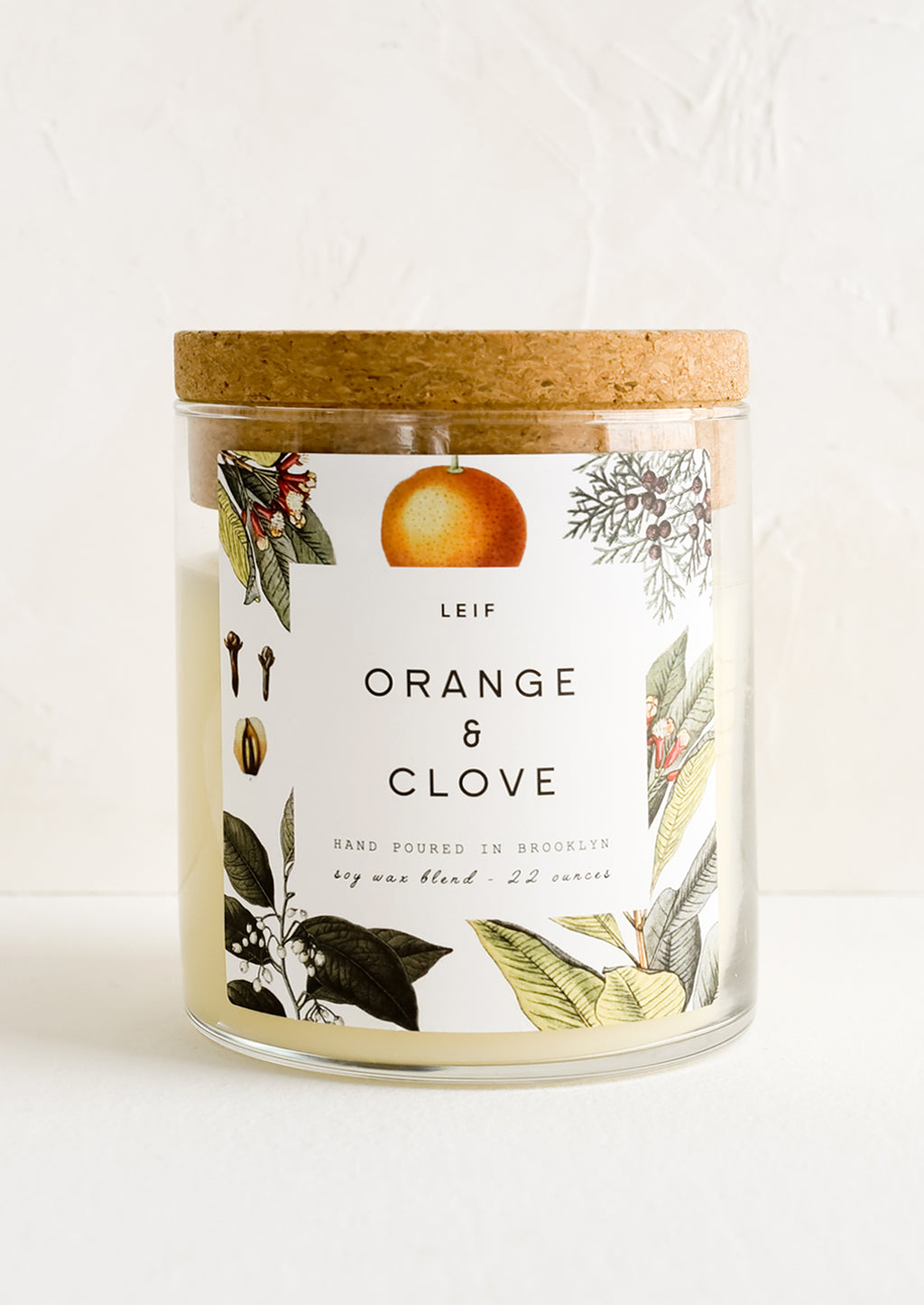 Orange & Clove: A glass jar candle in Orange & Clove scent with botanical print label.