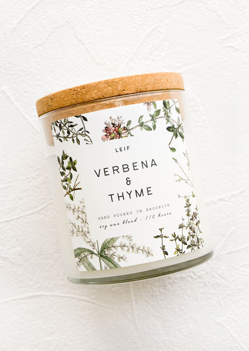 Verbena & Thyme: A glass jar candle in Verbena & Thyme scent with botanical print label.