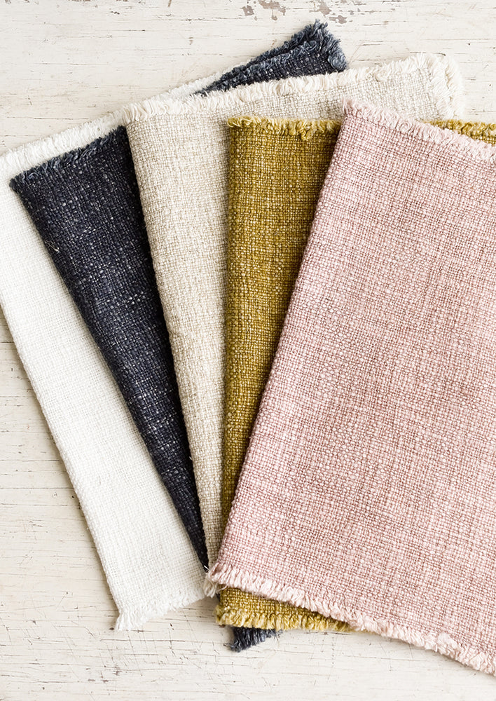 A stack of slub boucle textured placemats in assorted colors.