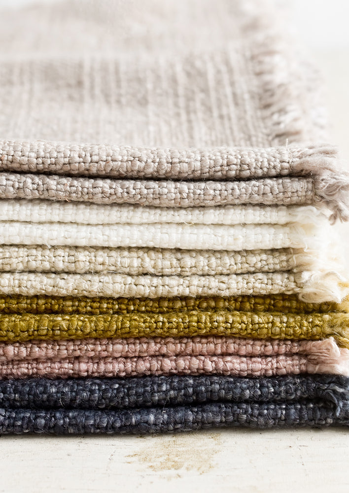 A stack of slub boucle textured placemats in assorted colors.