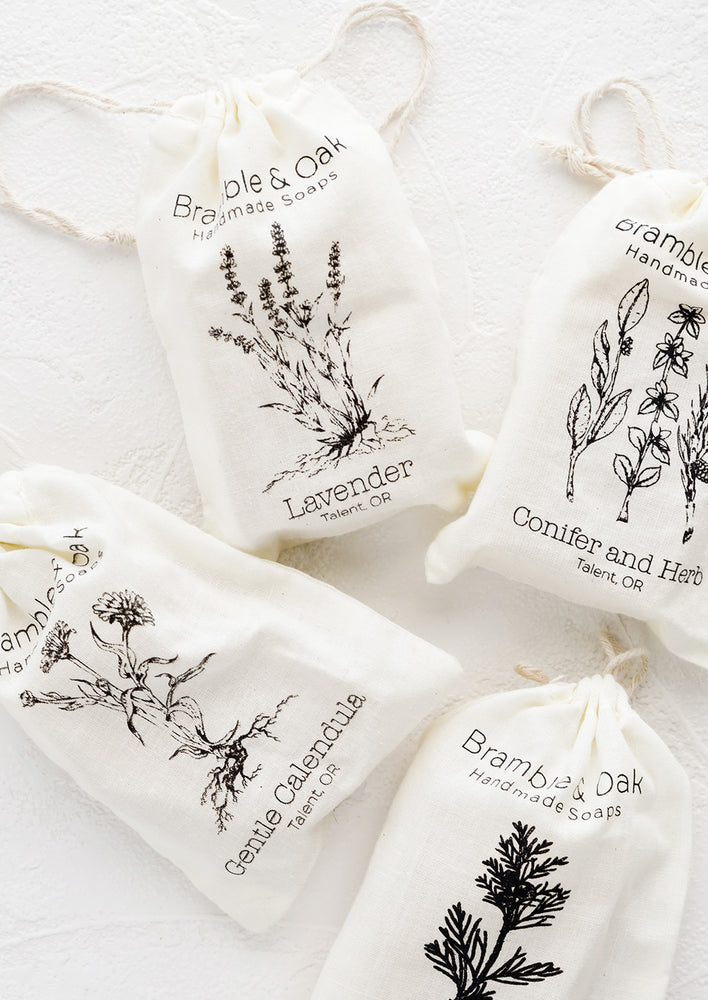 Muslin bag packaging for bar soap with botanical imagery.