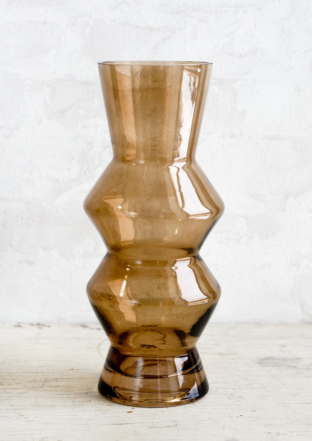 1: A tall glass vase in brown glass with zig zag silhouette.