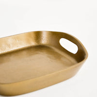 2: Square catchall tray in unpolished brass with raised sides, cutout handles at two sides
