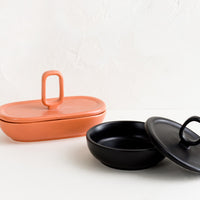 3: Lidded ceramic containers in orange and black.