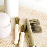 2: Assortment of hand carved wooden brushes on a console table