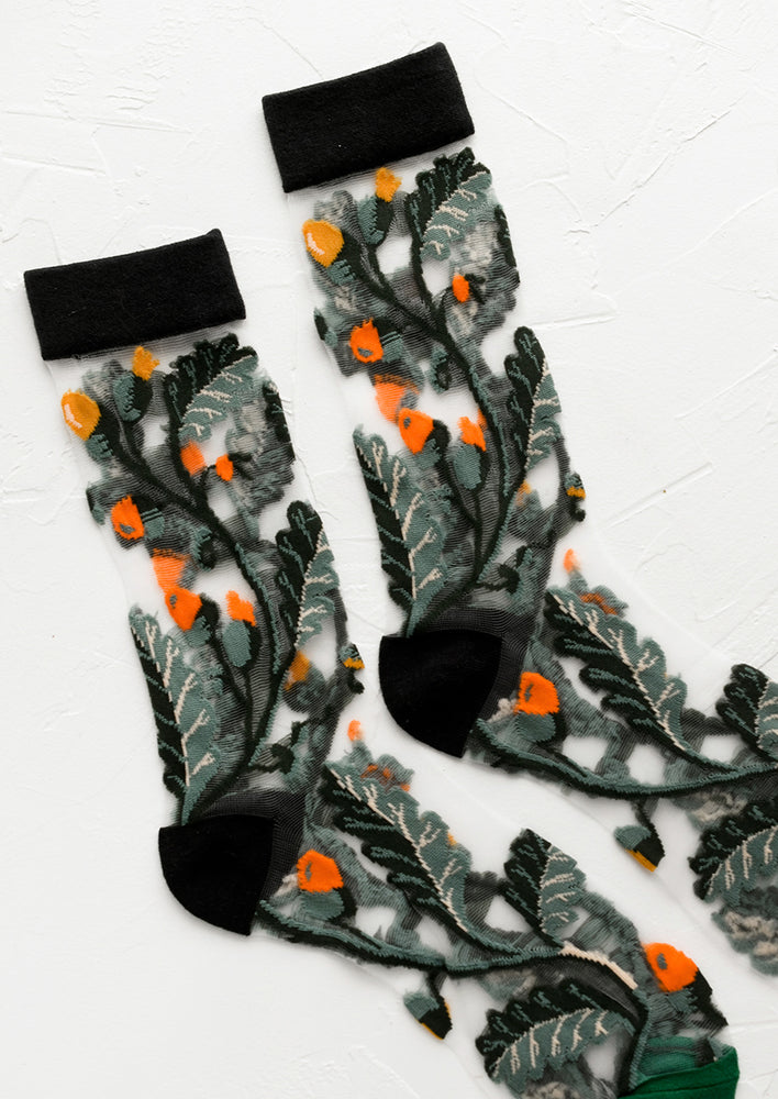 A pair of black sheer socks with green and orange vine print.