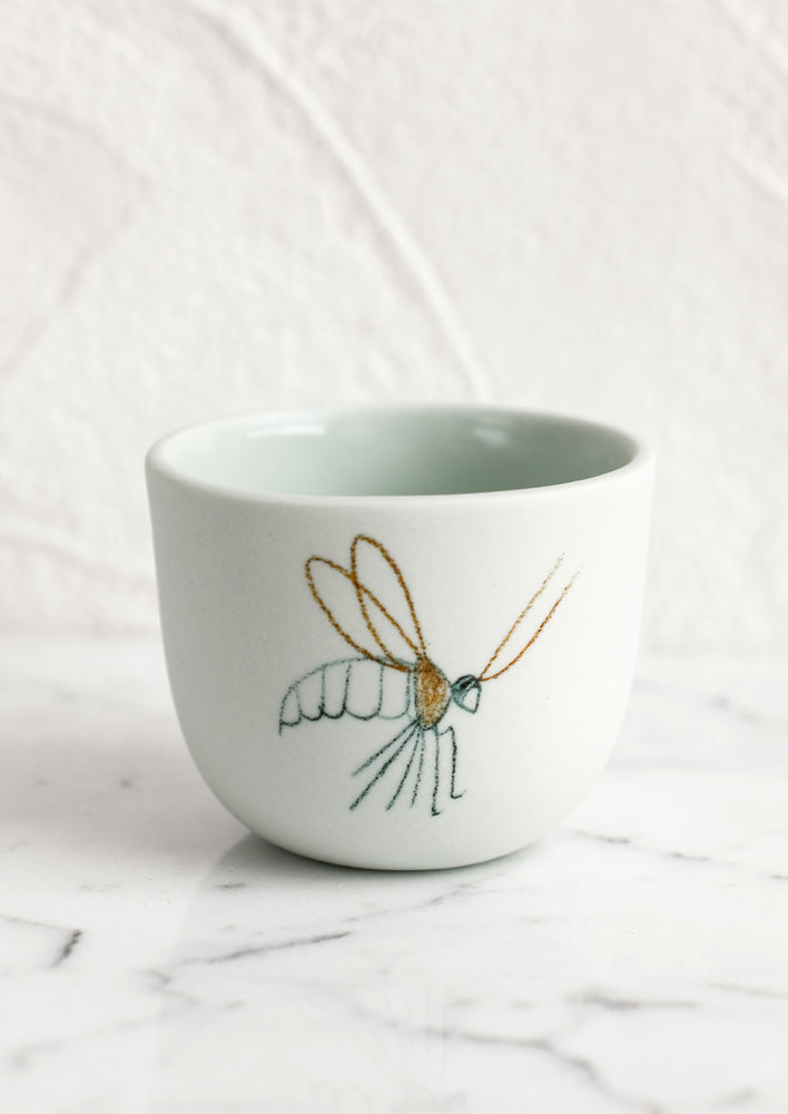 An extra small mint porcelain cup with cranefly sketch.