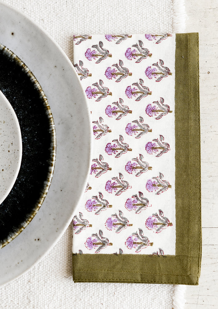 2: A pair of block printed floral napkins in olive and purple.