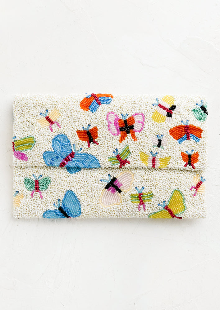 1: A white beaded clutch with front foldover flap, with multicolor butterfly design.