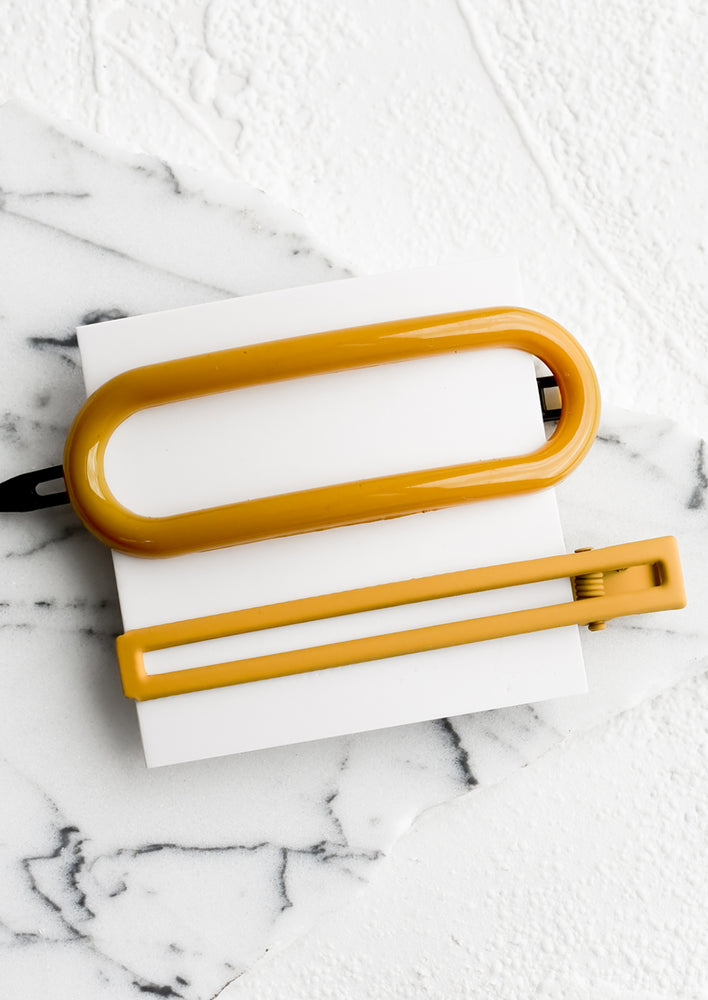 Mustard: A pair of hair clips in oval and rectangular shapes in mustard.