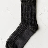 Slate Grey: A pair of cable knit socks with ruffled ankle in charcoal.