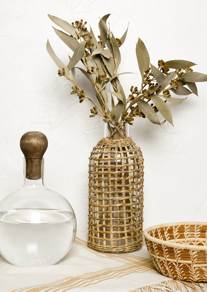 2:  A glass carafe with seagrass wrapped vase.
