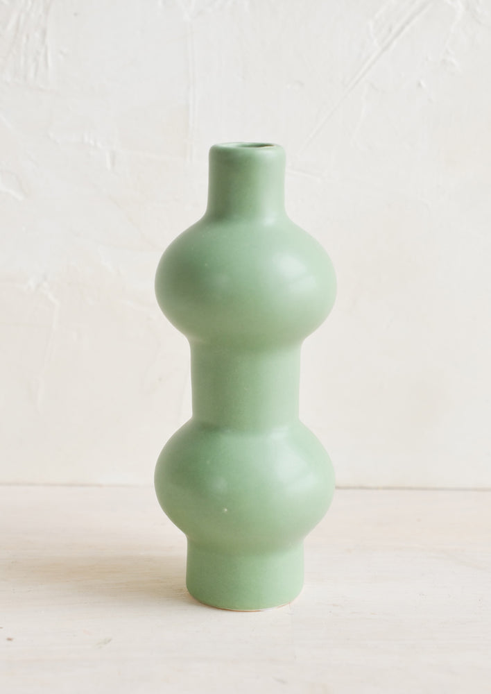 A mint green ceramic bud vase in curvy double sphere silhouette.