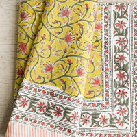1: A block printed tablecloth in yellow, pink and green floral.