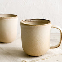 1: Matte tan ceramic coffee mugs.