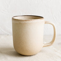 Sand: A ceramic coffee mug in matte tan glaze.