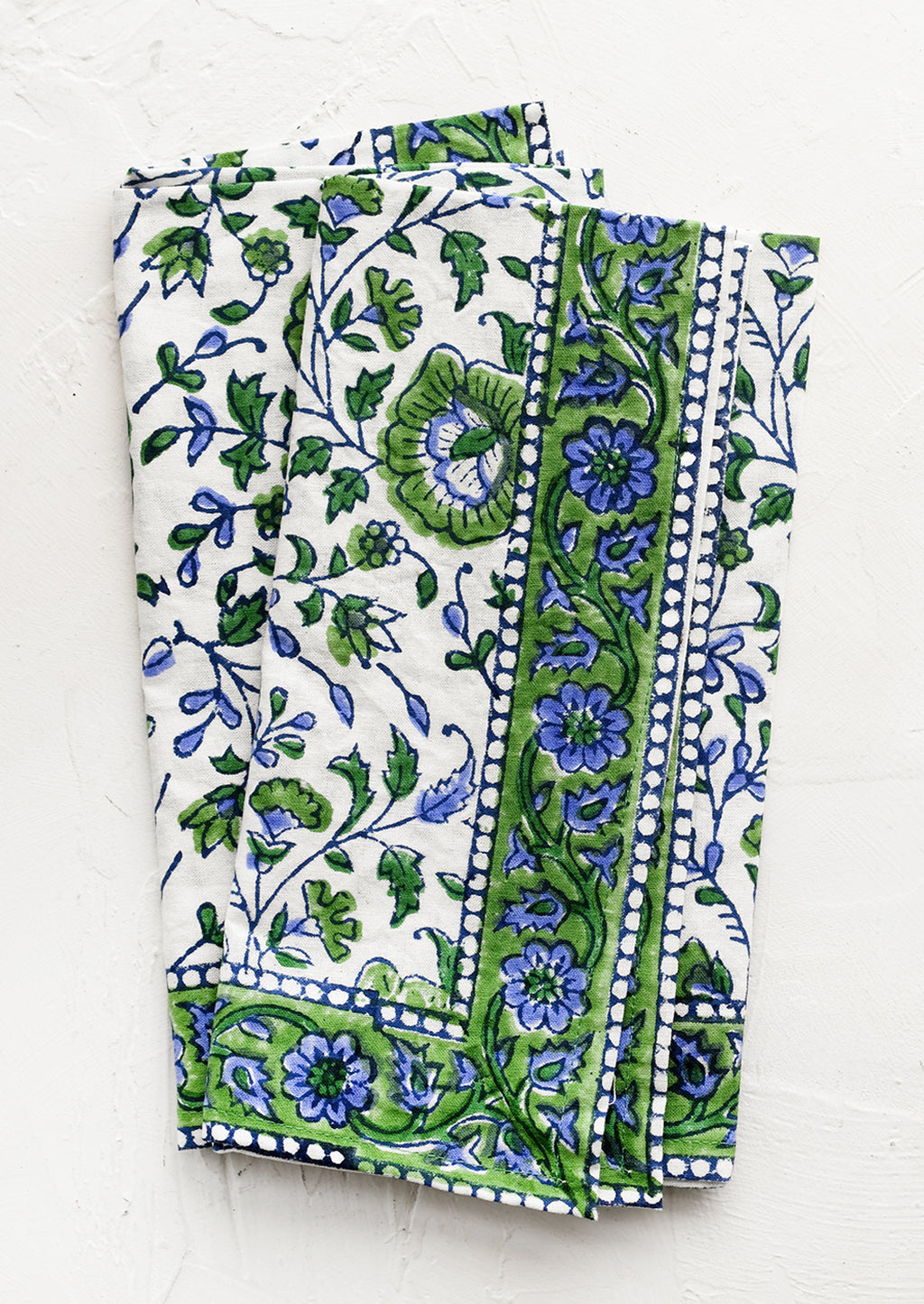 1: A set of two block printed napkins in blue and green floral print.