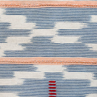 2: A throw pillow made from indigo baule fabric with peach stripes.