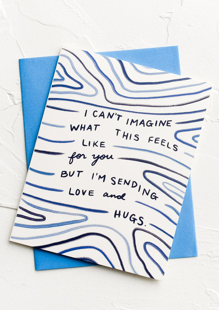 A greeting card with text reading "I can't imagine what this feels like for you but I'm sending love and hugs".
