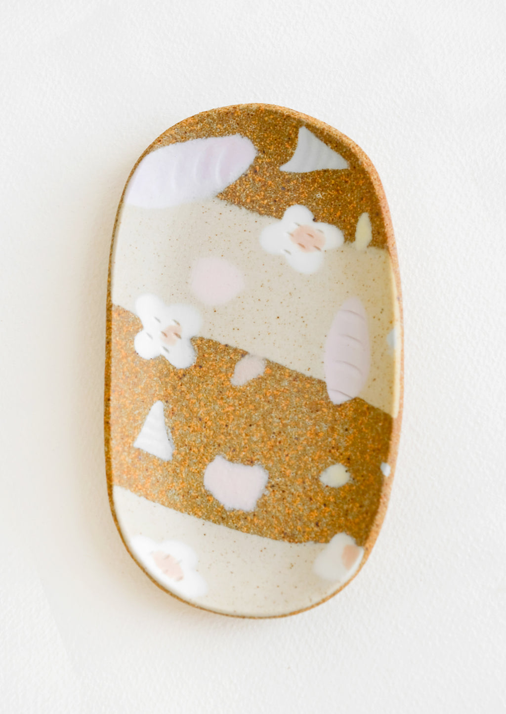 2: A small oval ceramic tray with pastel flower and terrazzo pattern.