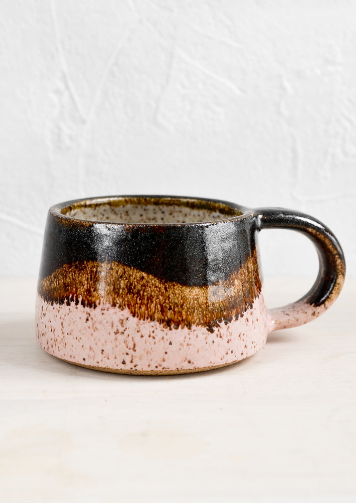 A short coffee mug in layered glazes.