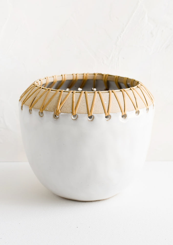 Large: A white ceramic planter in round shape with rattan trim around top.
