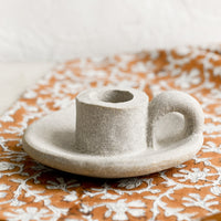Light: A ceramic taper holder in light colored clay.