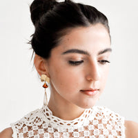 2: Model shot featuring woman wearing earrings and white top.