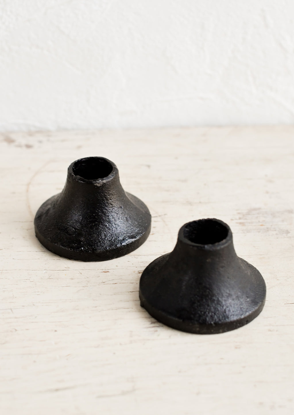 1: Two ceramic taper candle holders in black cast iron.