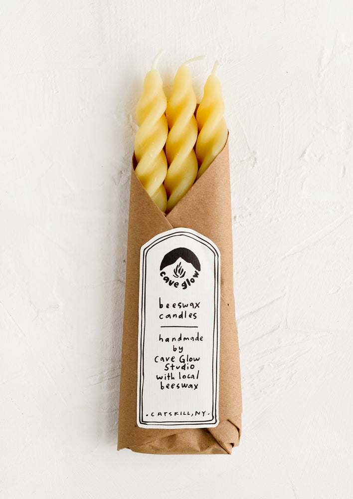Natural Beeswax: Three spiral beeswax tapers wrapped in kraft paper.