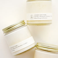 1: Three white glass jars with gold lids, and white labels with black text