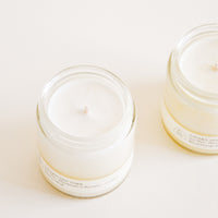2: Two glass jars with white candle and wick inside