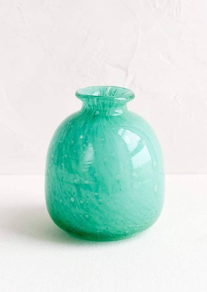 A turquoise bud vase in glass.
