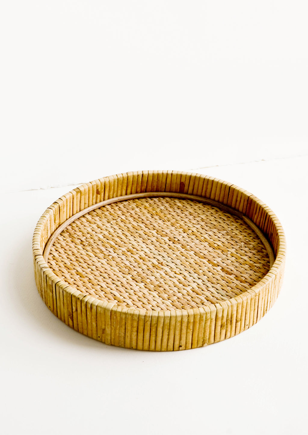 1: Round serving tray with raised rim, made from woven rattan