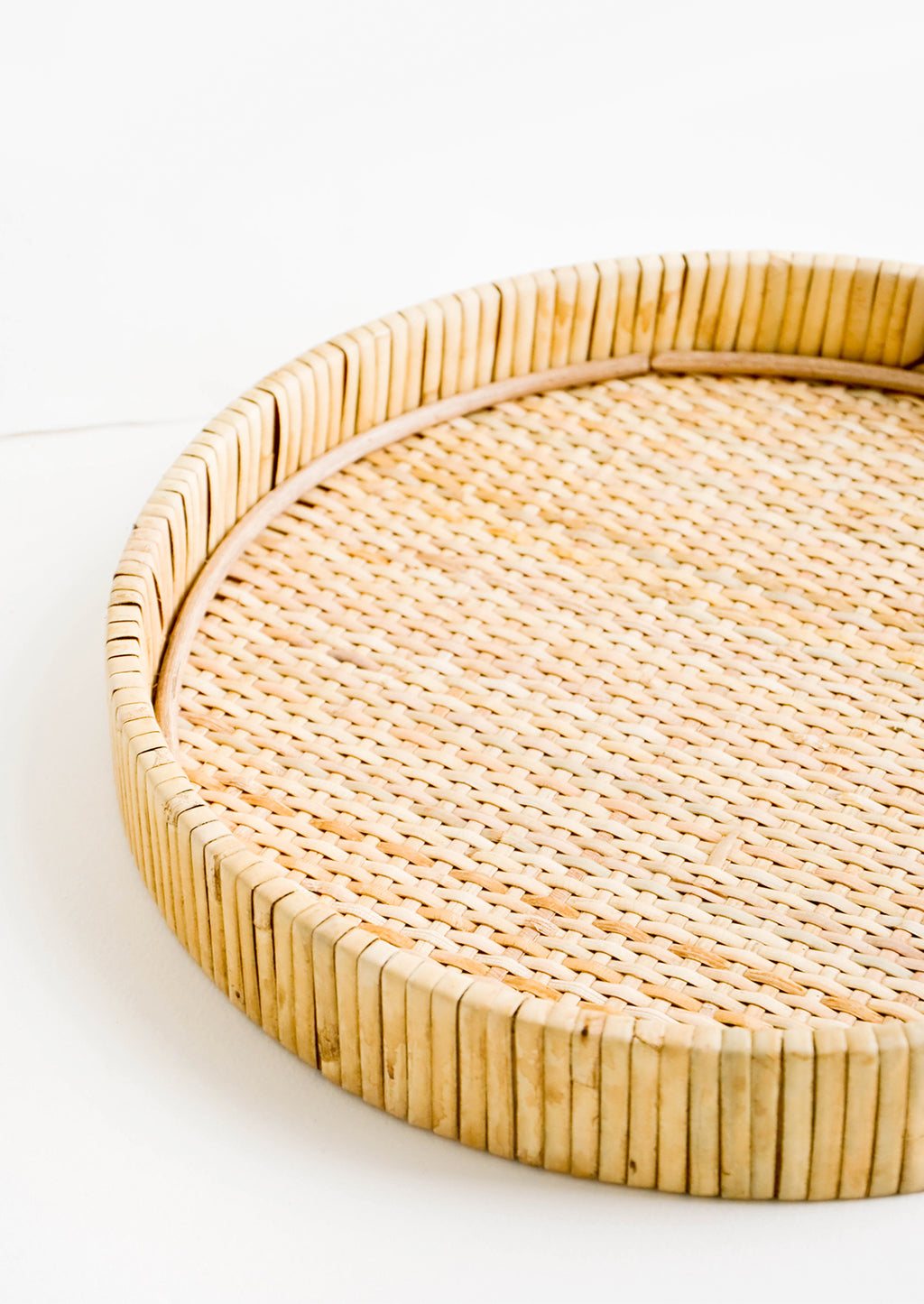 2: Round serving tray with raised rim, made from woven rattan