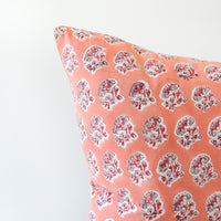 2: A detail shot of a block printed pillow with a pink, grey, and red floral design.