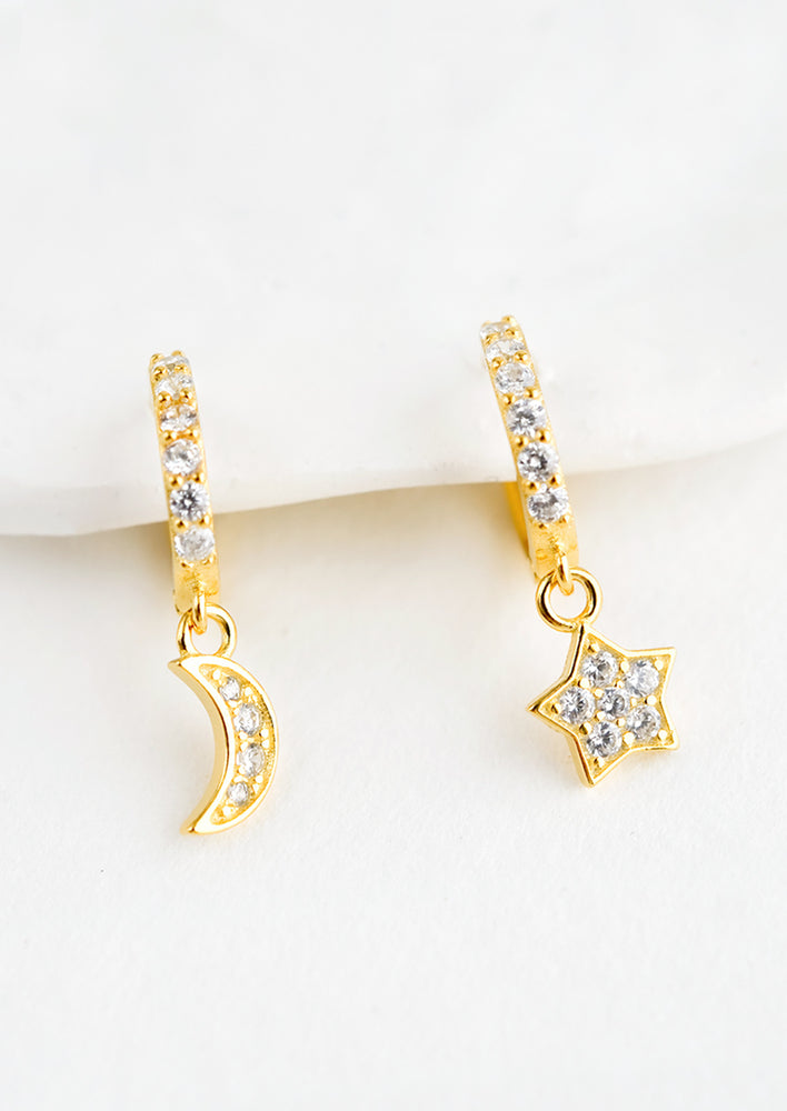 1: A pair of gold earrings in shape of moon and star with clear crystals.
