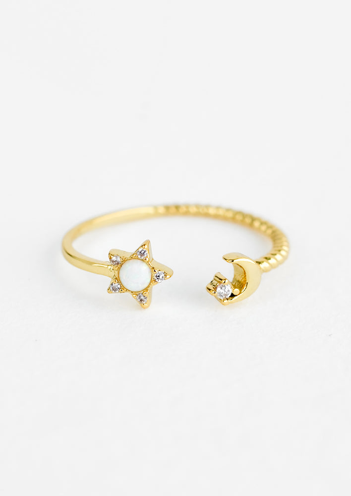 A gold open sized ring with opal star on left side and moon on right side.
