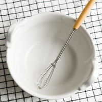 1: A white ceramic bowl with top handles that fit included whisk.
