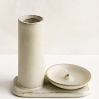 1: A tan ceramic incense holder with stand and incense holder.