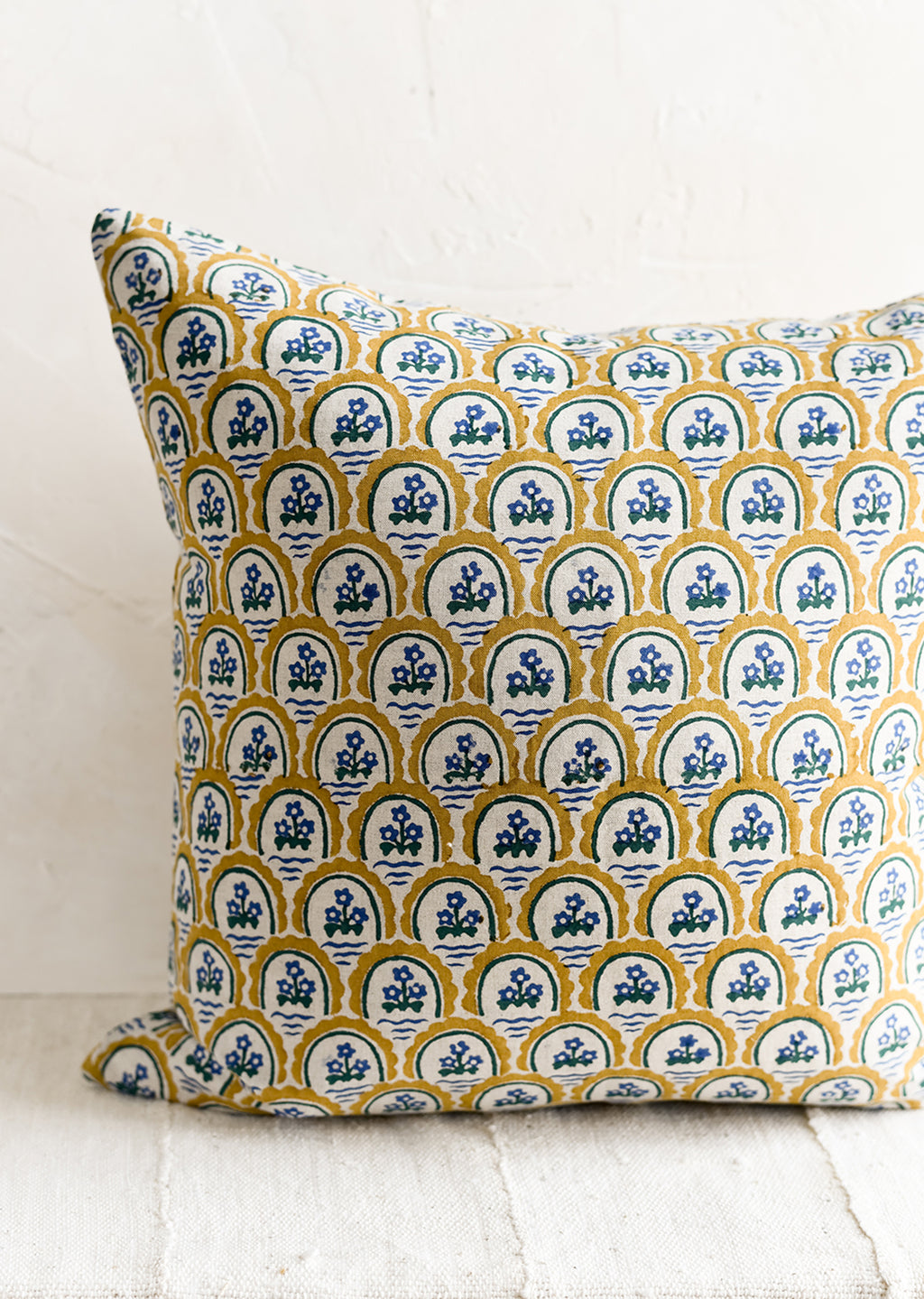 3: A block printed pillow with yellow and blue floral motif.