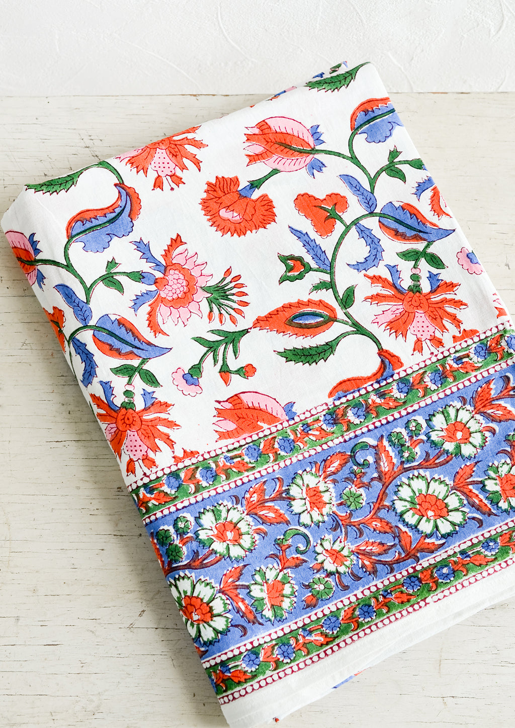 1: A colorful block printed cotton tablecloth folded on a table.