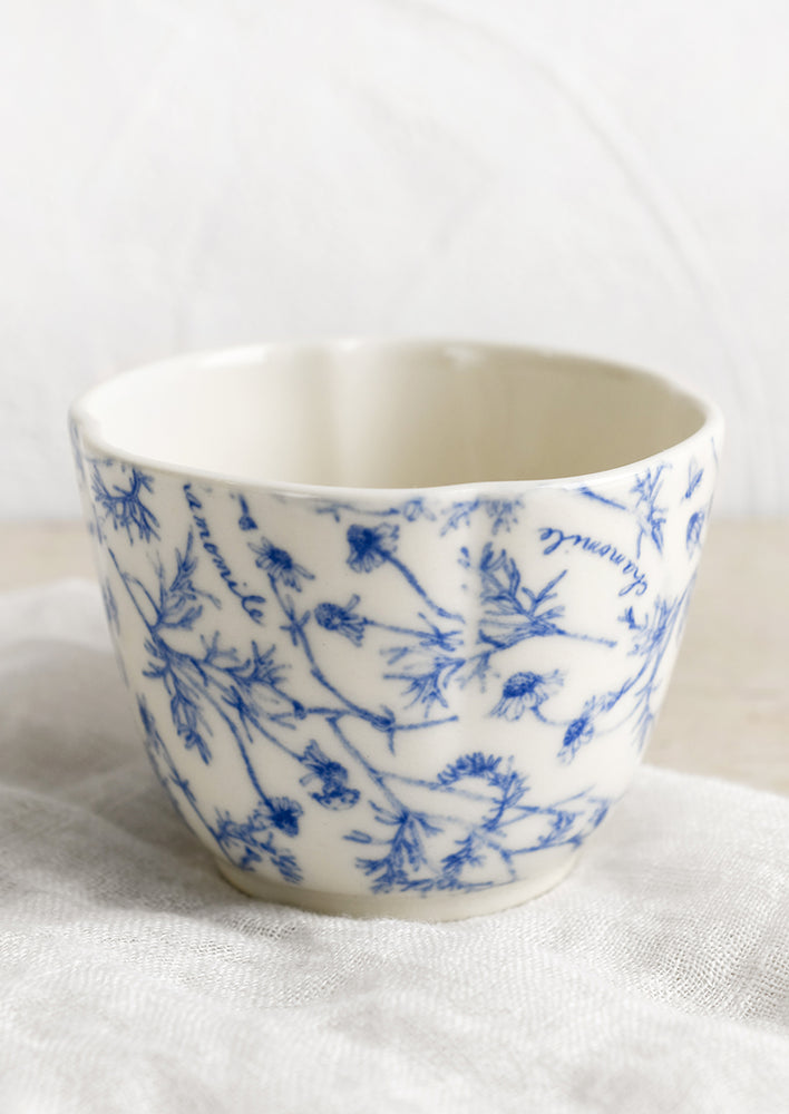 A blue and white cup with floral pattern.