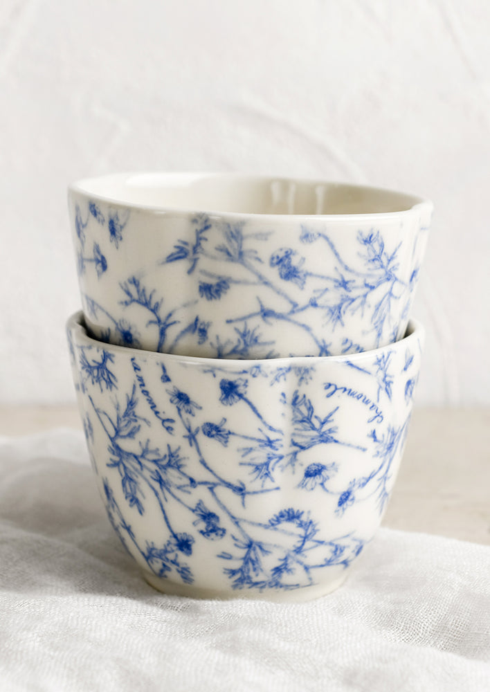 A blue and white cup with floral pattern.