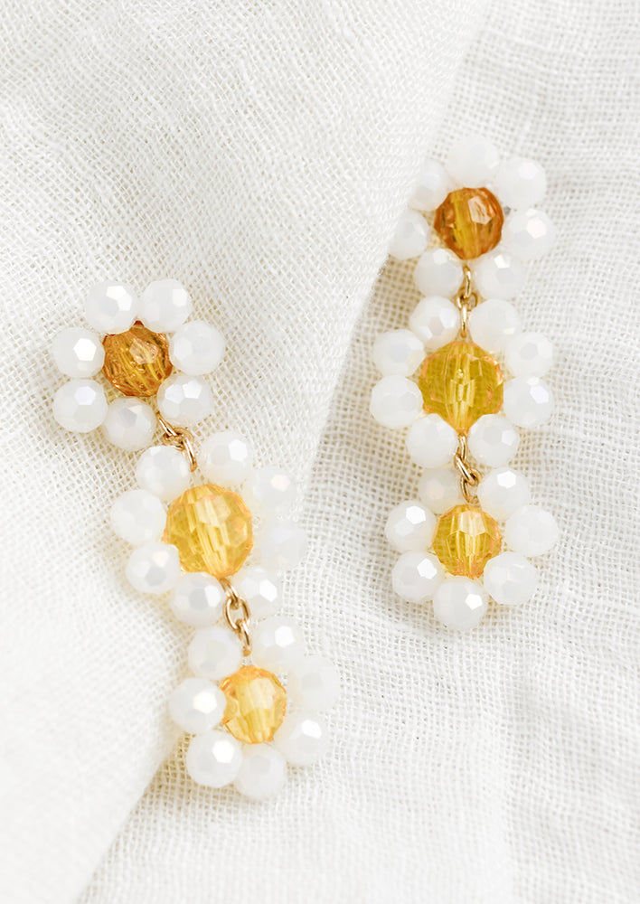 A pair of beaded earrings with three flower.