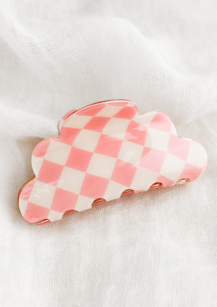 A cloud shaped hair claw in pink and white checker.